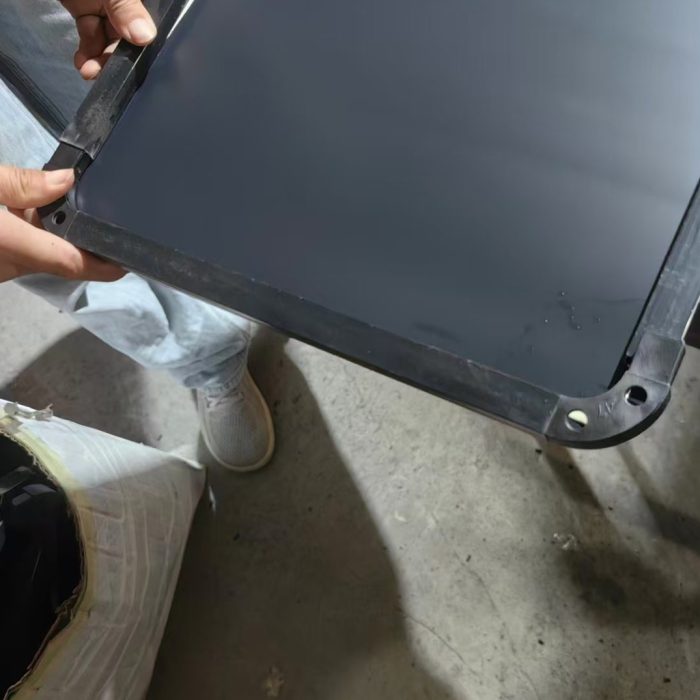 Corner cap and screws on the black frame of a full-length mirror