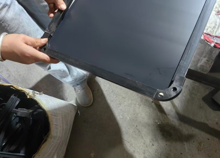Moulded corner cap being fitted to the black frame of a full-length mirror