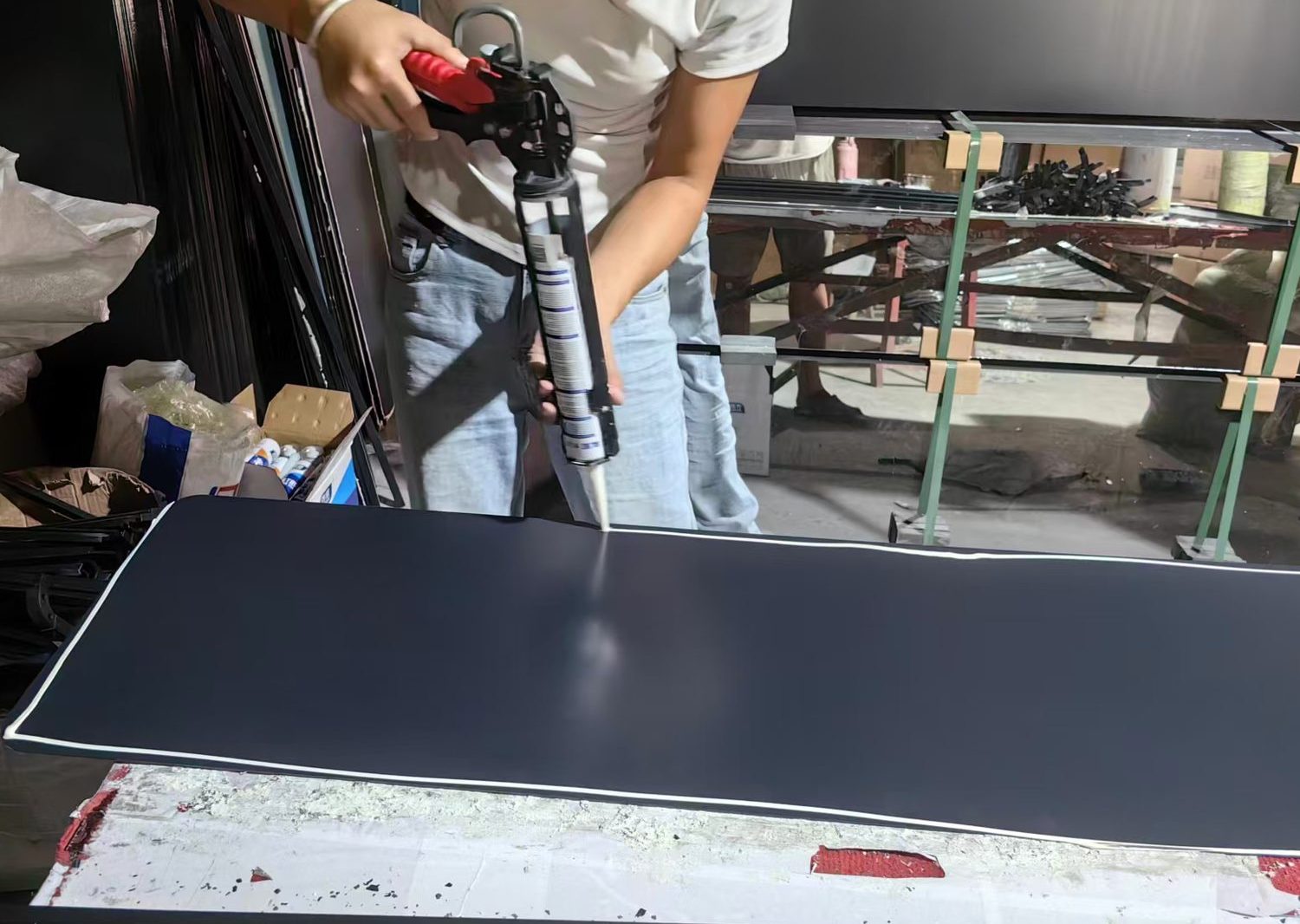 Sealant applied along the edge of a mirror back panel