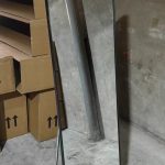 Full-length mirror standing on its folding stand in the factory workshop