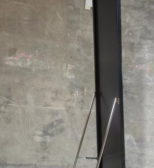 Side view of a full-length mirror with its folding metal stand open